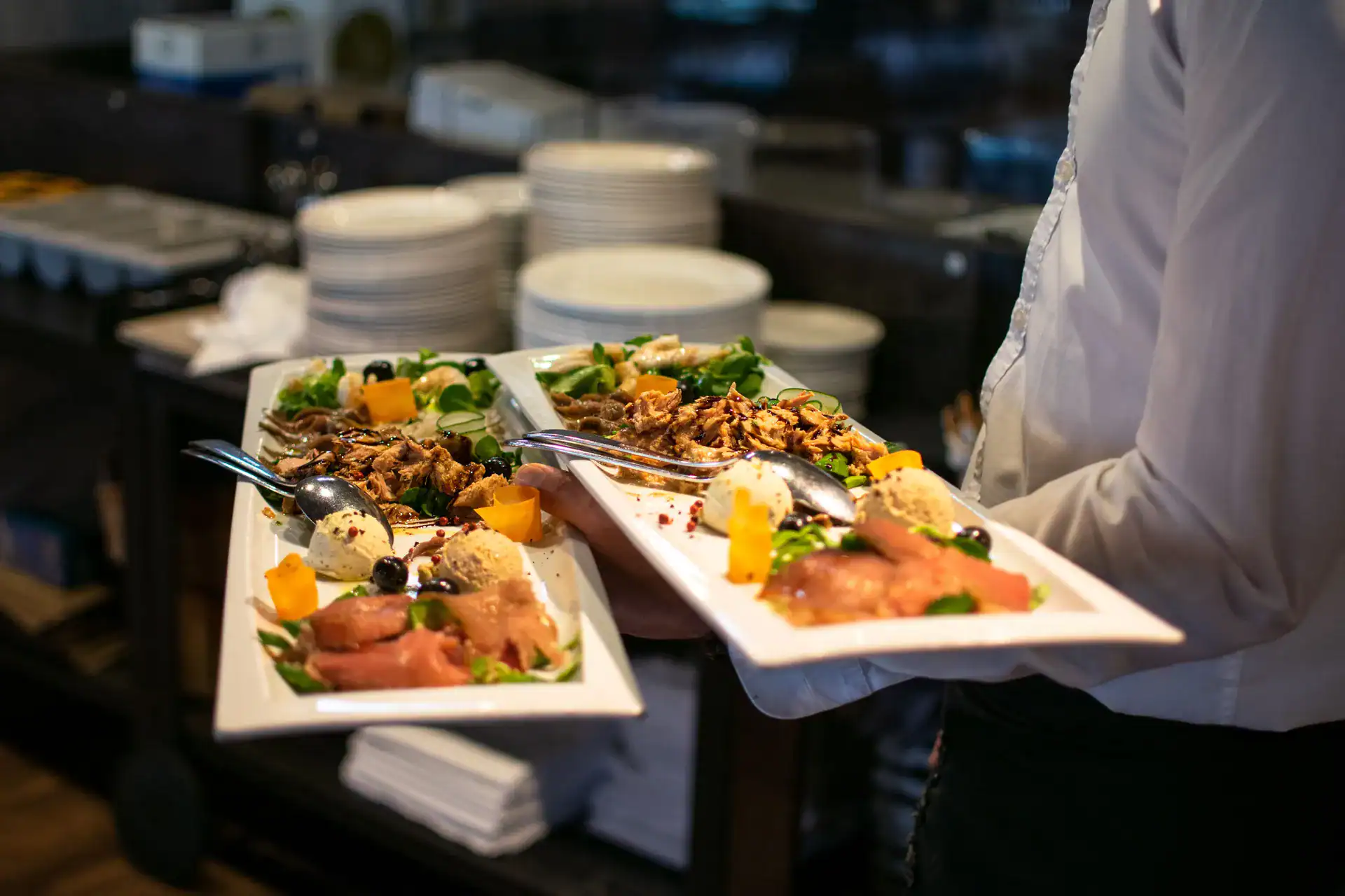 A server presenting plated canapés